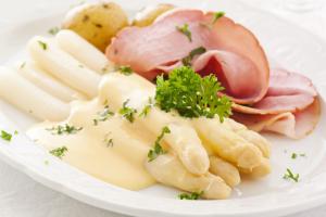 un plato de comida con jamón y pasta. en Eemshotel, en Delfzijl