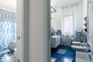 a blue and white bathroom with a sink and a toilet at A casa di Monachella in Gaeta