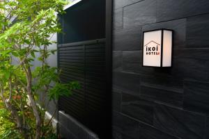 ikoi HOTEL في كيوتو: جدار أسود مع علامة تشير إلى أن الفندق حار