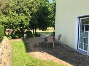 eine Terrasse mit einem Tisch und Stühlen im Hof in der Unterkunft Kleine Ferienwohnung bei Kappeln an der Schlei in Kappeln