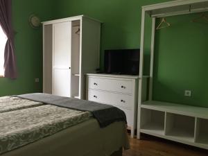 um quarto com uma cama e uma cómoda com uma televisão em Апартамент ELSOR em Burgas