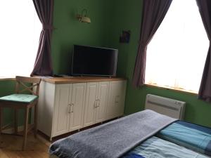 um quarto com uma cama e uma televisão de ecrã plano em Апартамент ELSOR em Burgas