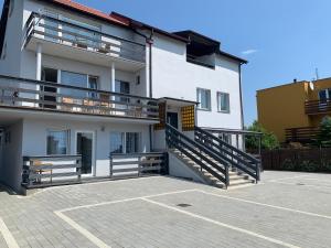 un grande edificio bianco con balcone e parcheggio di Marinas Rewa a Rewa