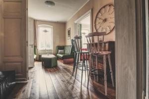 een woonkamer met een klok aan de muur en krukken bij OPERA Hostel in Erfurt