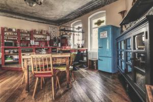 een keuken met een tafel en stoelen en een blauwe koelkast bij OPERA Hostel in Erfurt