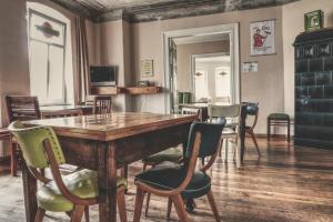 een eetkamer met een houten tafel en stoelen bij OPERA Hostel in Erfurt