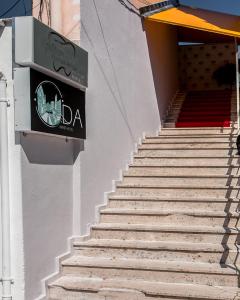 un conjunto de escaleras con una señal en el lateral de un edificio en ODA Aparthotel Shkodër, en Shkodër