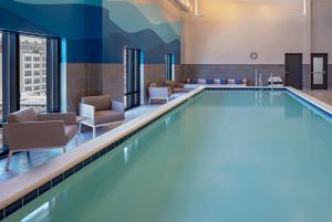 uma piscina num quarto de hotel com cadeiras em Hyatt House Indianapolis Downtown em Indianápolis