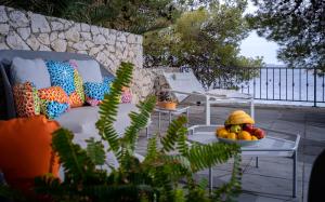 a couch and a table with a bowl of fruit at Pine Beach Villa in Hvar