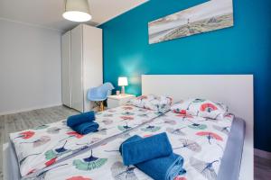 una camera con letto e pareti blu di Apartamenty Olivia a Władysławowo