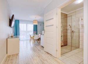 un bagno con doccia e una cucina con tavolo di Apartamenty Olivia a Władysławowo