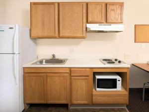 eine kleine Küche mit Spüle und Kühlschrank in der Unterkunft WoodSpring Suites Merrillville in Merrillville