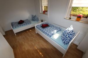 two beds in a room with blue and white pillows at Ferienwohnung Both in Wernigerode