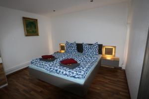 a bedroom with a bed with blue and red pillows at Ferienwohnung Both in Wernigerode