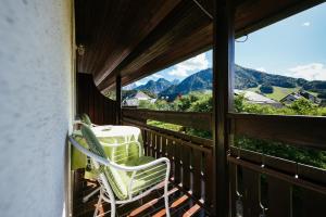 a balcony with a table and chairs and a view of mountains at Penzion Livada in Kranjska Gora