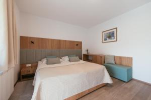 a bedroom with a large bed and a chair at Penzion Livada in Kranjska Gora