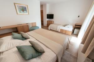 a hotel room with two beds and a television at Penzion Livada in Kranjska Gora