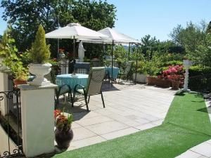 un patio con mesa y sombrilla en B&B Madonna della Neve, en Stresa