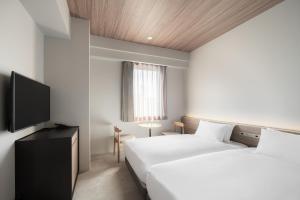 Cama ou camas em um quarto em Nest Hotel Hiroshima Ekimae