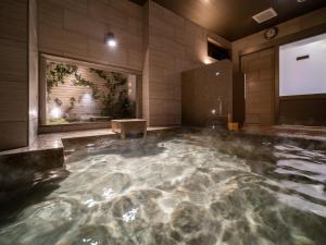 uma grande piscina de água numa casa de banho em Super Hotel Higashi-Maizuru em Maizuru