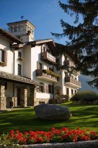 un gran edificio blanco con flores en un patio en Hotel Milleluci, en Aosta