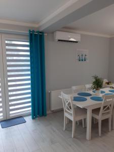 uma sala de jantar com mesa e cadeiras e cortinas azuis em Apartament FAMILY- klimatyzacja em Oświęcim