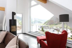 a living room with a couch and a chair and a fireplace at Rooftop Moselsuite in Cochem