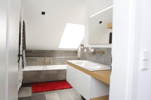 a bathroom with a sink and a bath tub at Rooftop Moselsuite in Cochem