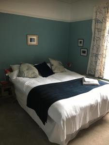 a large bed in a bedroom with a blue wall at Old Church House in Newport