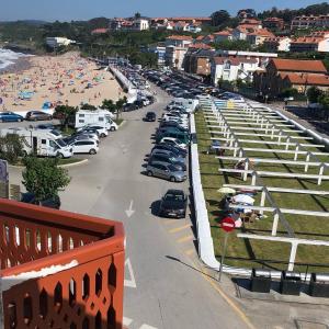 parking z grupą samochodów zaparkowanych na plaży w obiekcie Buhardilla Comillas Beach en Primera Línea de Playa, Wifi, Netflix w mieście Comillas