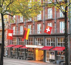 ein Gebäude mit Flaggen davor in der Unterkunft Hotel Baseler Hof in Hamburg