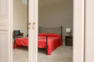 een slaapkamer met een rood bed en een stoel bij B&B Santi Medici in Bitonto