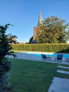 une piscine avec des chaises et un château en arrière-plan dans l'établissement B&B La Vita Verde, à Susteren