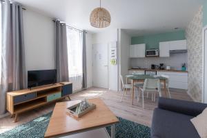 un soggiorno con TV e una cucina con tavolo di Trankil-Apparts Centre 2 a Saint-Quentin