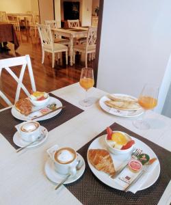 a table topped with plates of food and cups of coffee at Villa Turistica de Bubion in Bubión