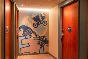 un pasillo con una pintura de un hombre en una bicicleta en ibis budget Cannes Centre Ville, en Cannes