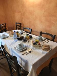 a table with a white table cloth with food on it at B&B Linu Ruiu in Santu Lussurgiu