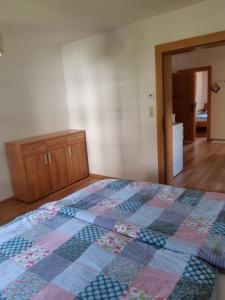 een slaapkamer met een bed met een quilt bij Haus Moser in Altaussee