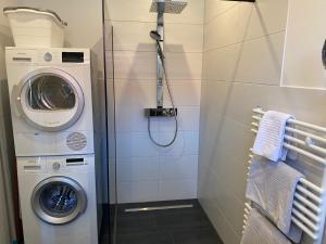 een badkamer met een wasmachine en een wasmachine bij Freimuth`s Hof in Südbrookmerland