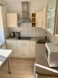 een keuken met witte kasten en een wastafel bij Centro Apartamentai in Zarasai