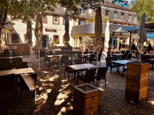 an outdoor restaurant with tables and chairs and umbrellas at Blesius Garten in Trier