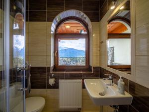 a bathroom with a sink and a toilet and a window at Strama Kościelisko in Kościelisko