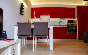 una cocina con armarios rojos y una mesa con sillas. en Holiday House Viola, en Tirano