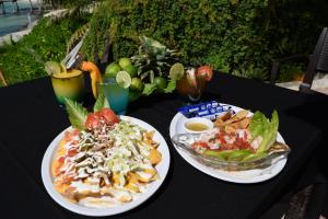 uma mesa preta com dois pratos de comida em Casa de los Sueños Hotel Boutique em Ilha das Mulheres