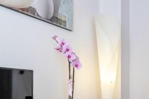 a vase with pink flowers in a room at An der Abzucht in Goslar