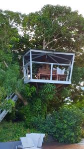 una casa en un árbol con sillas y mesas en un árbol en Villa Mango, en Le Gosier