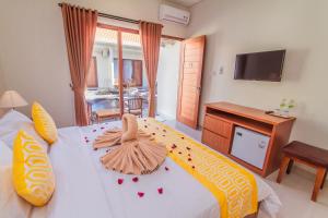 1 dormitorio con 1 cama grande y TV en Cening Ayu Sanur, en Sanur