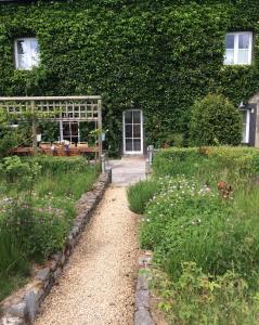 a garden with a pathway leading to a house at B&B La ferme du doux in Libramont