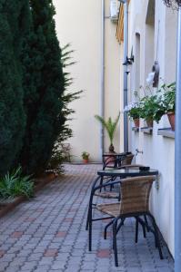 eine Gruppe von Tischen und Stühlen auf einer Terrasse in der Unterkunft Hotel Harka in Harkány