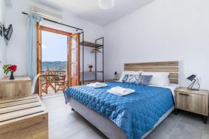 een slaapkamer met een groot bed en een balkon bij Nepheles in Skopelos Town